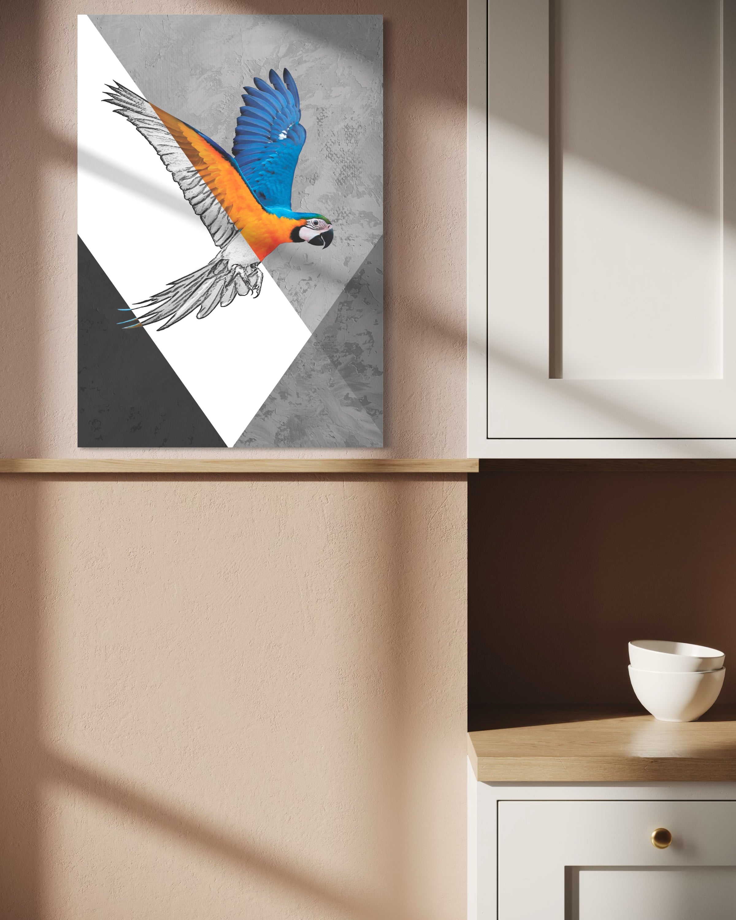 Quadro verticale con pappagallo blu e arancione in sagoma triangolare, cornice chiara.